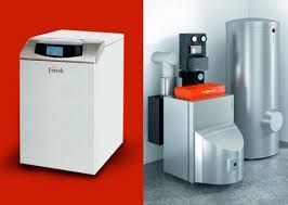 Dos unidades de calefacción modernas: un modelo cerrado de color blanco y una unidad plateada con un tanque de agua adjunto, sobre un fondo rojo y gris.