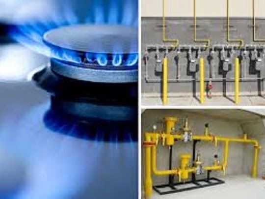 Llama de estufa de gas y tuberías de gas. Llama azul, tuberías amarillas, entorno industrial.