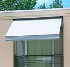 Un toldo blanco cuelga sobre una ventana de un edificio.