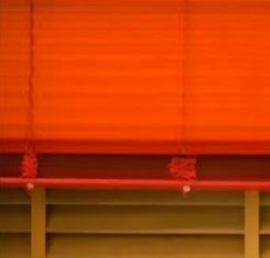 Un primer plano de una persiana roja en una ventana.