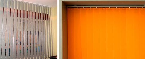 Una persiana vertical blanca y una persiana vertical naranja están colgadas en una ventana.