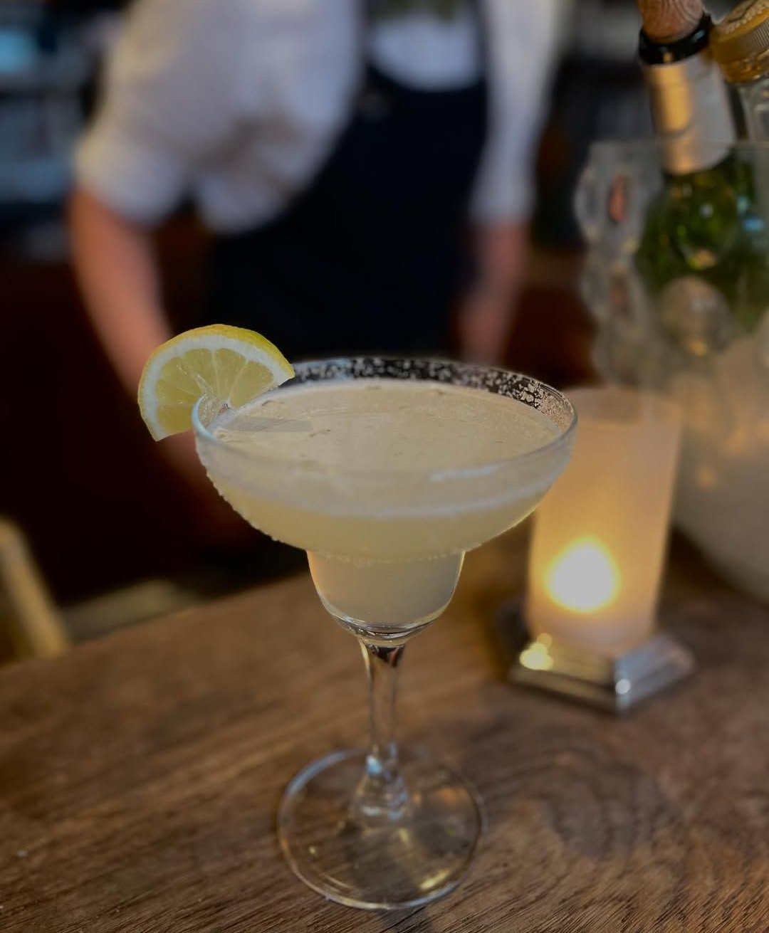 Un cocktail garni de citron vert, servi dans un verre au bord sucré