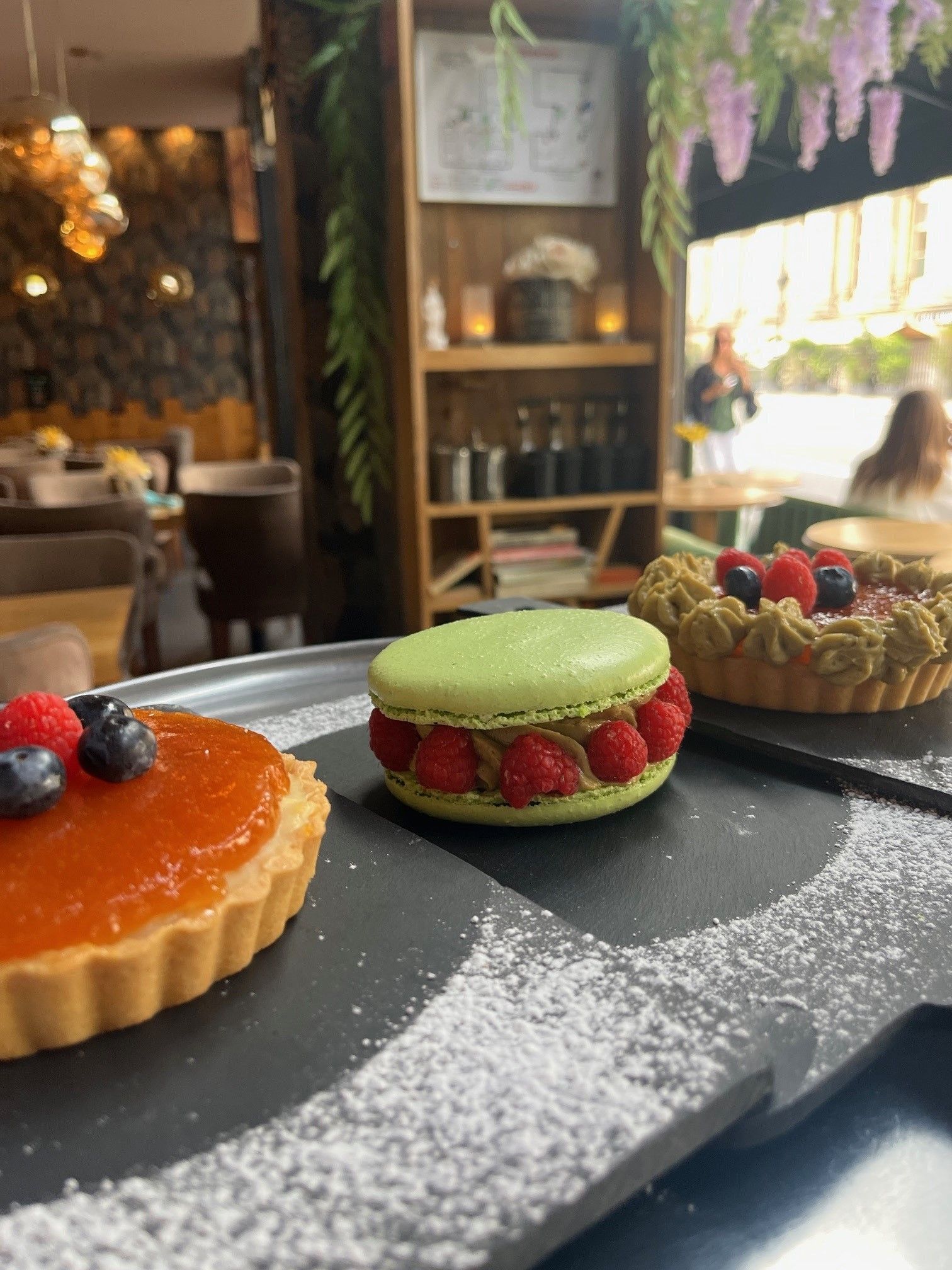 Une tarte aux fruits, un macaron à la framboise et une tarte aux fruits rouges
