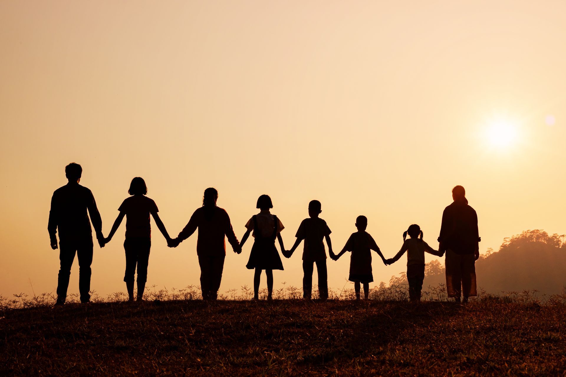 Une famille se tient la main à contre-jour
