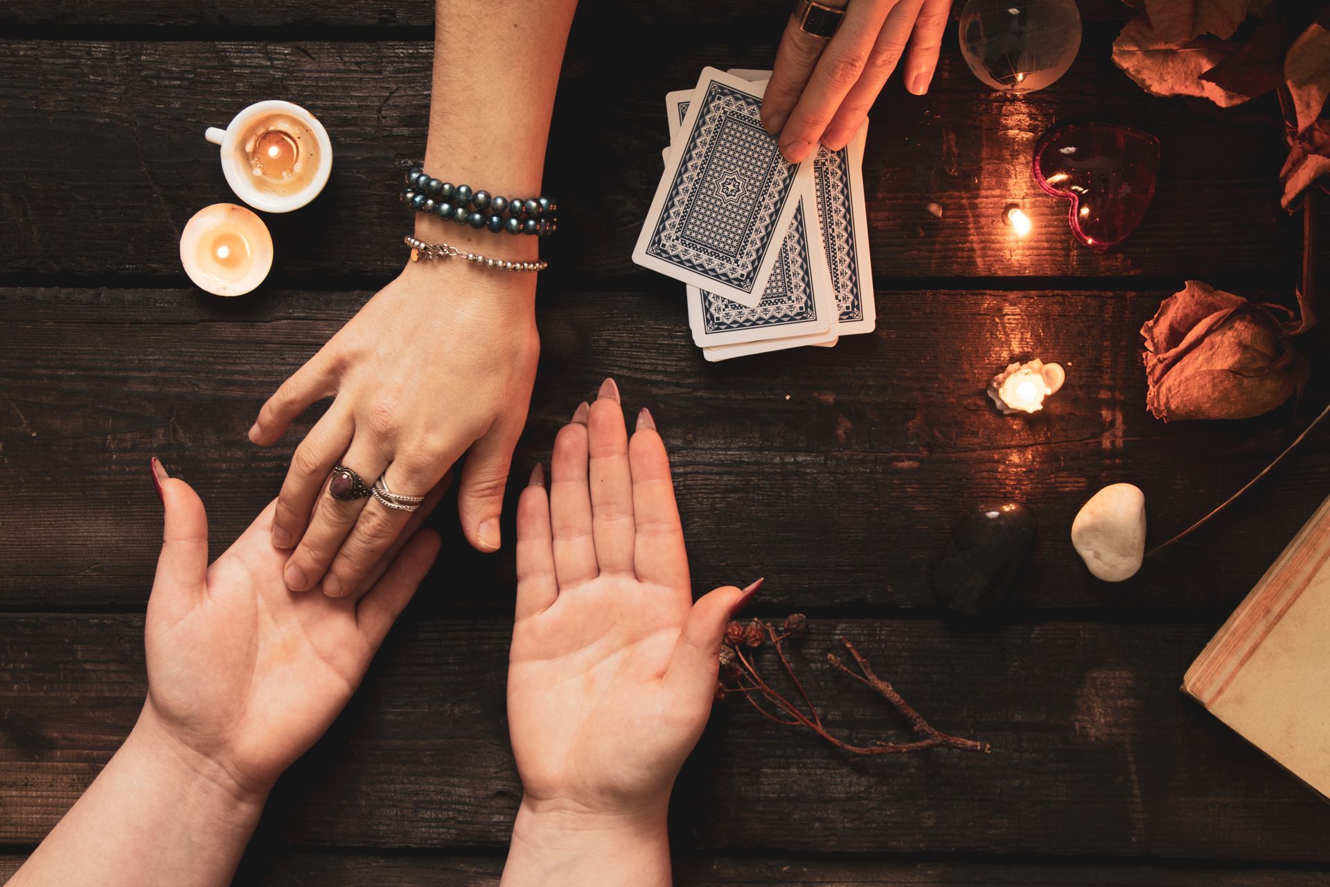 Cartes, bougies et pierre sur une table en bois sombre