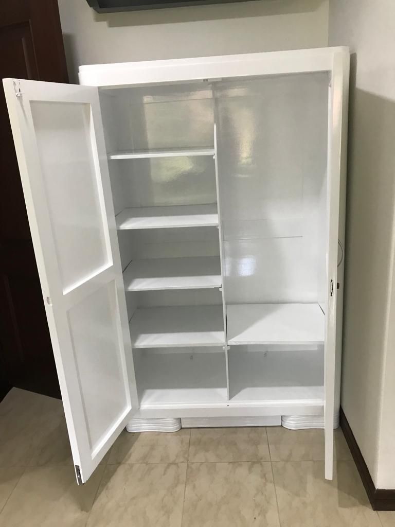 Nevera blanca abierta con estantes y compartimentos en la puerta, en una cocina.