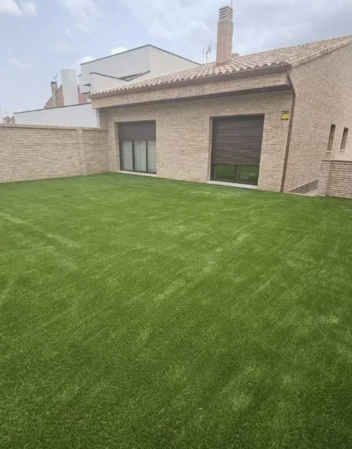 Una casa con un gran césped delante de ella.
