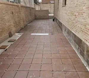 Una pasarela de baldosas entre dos edificios de ladrillo.