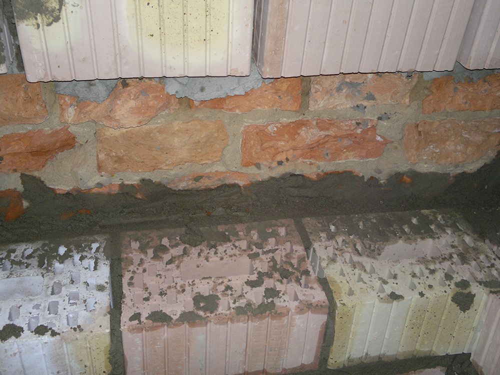 Eine Nahaufnahme einer Ziegelmauer, bei der ein paar Ziegel fehlen