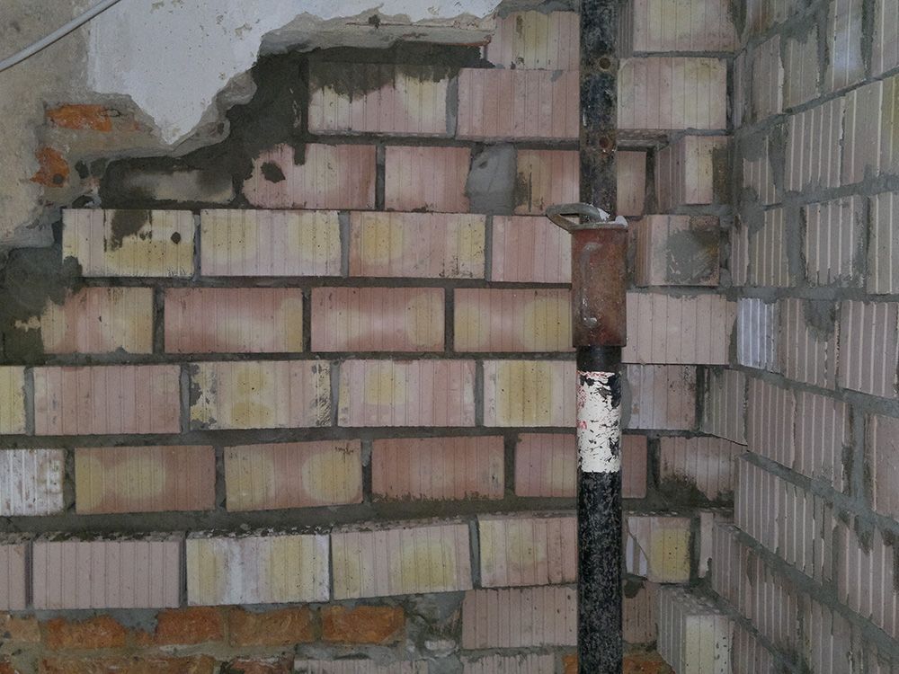 Eine Ziegelwand, aus der ein Rohr herauskommt