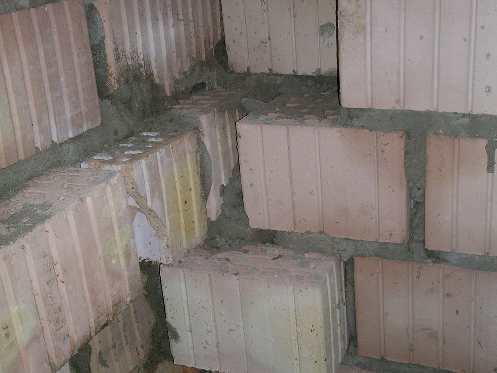 Eine Backsteinmauer mit vielen übereinander gestapelten Backsteinen.