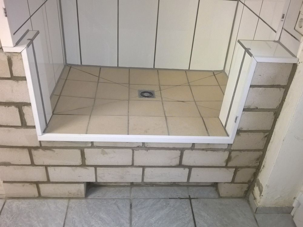 Ein Badezimmer mit Ziegelwand und Fliesenboden