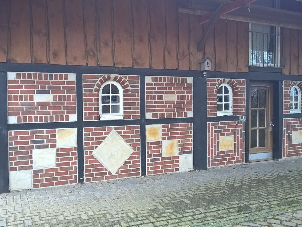 Ein Backsteingebäude mit Bogenfenstern und einer Tür