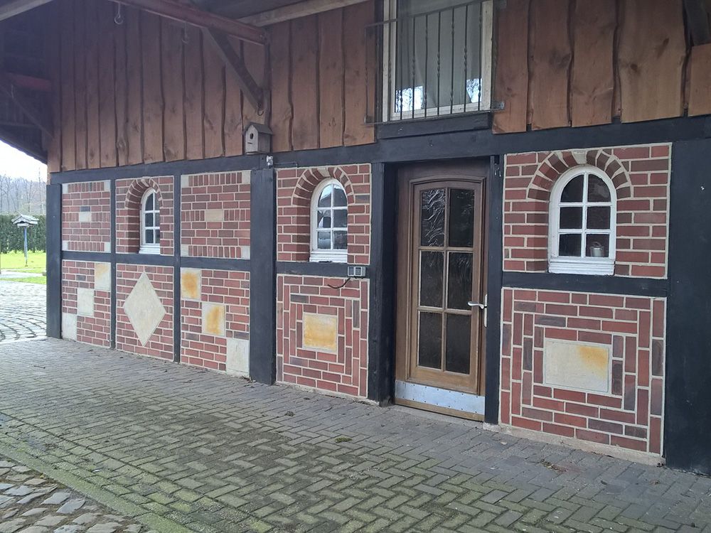 Ein Backsteingebäude mit Bogenfenstern und einer Tür