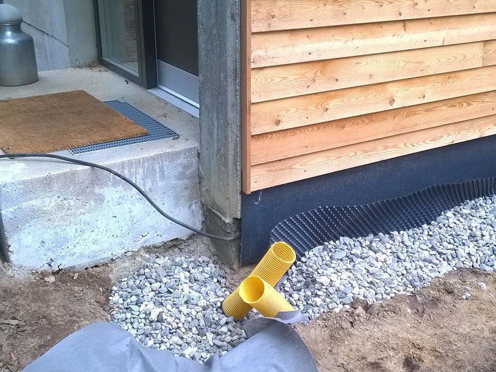 Ein gelbes Rohr liegt vor einem Holzgebäude