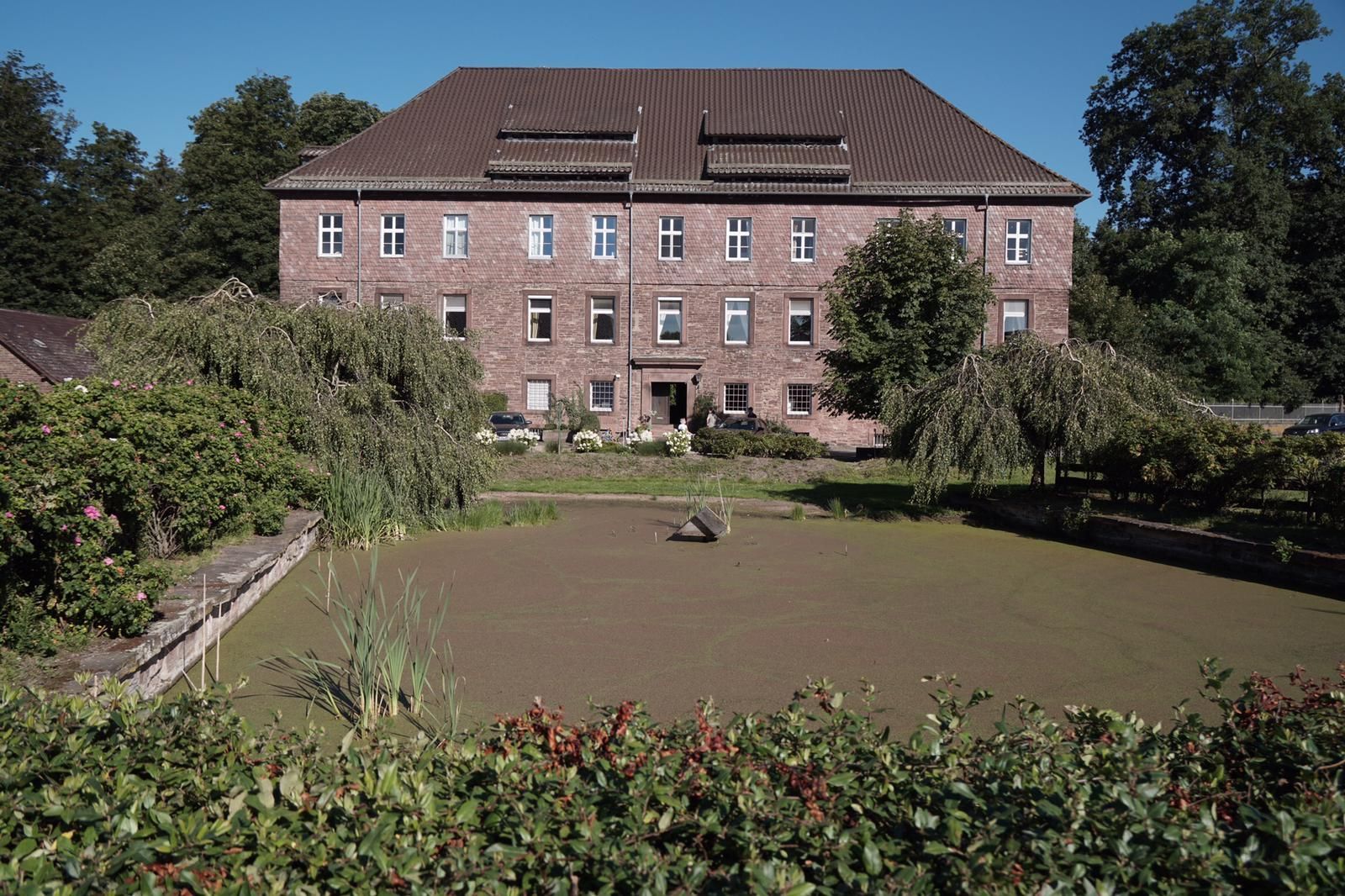 Ein großes Gebäude mit einem Teich davor