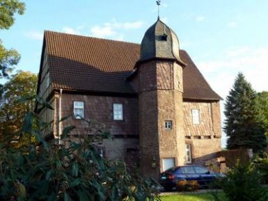 Ein großes Backsteingebäude mit einem davor geparkten Auto