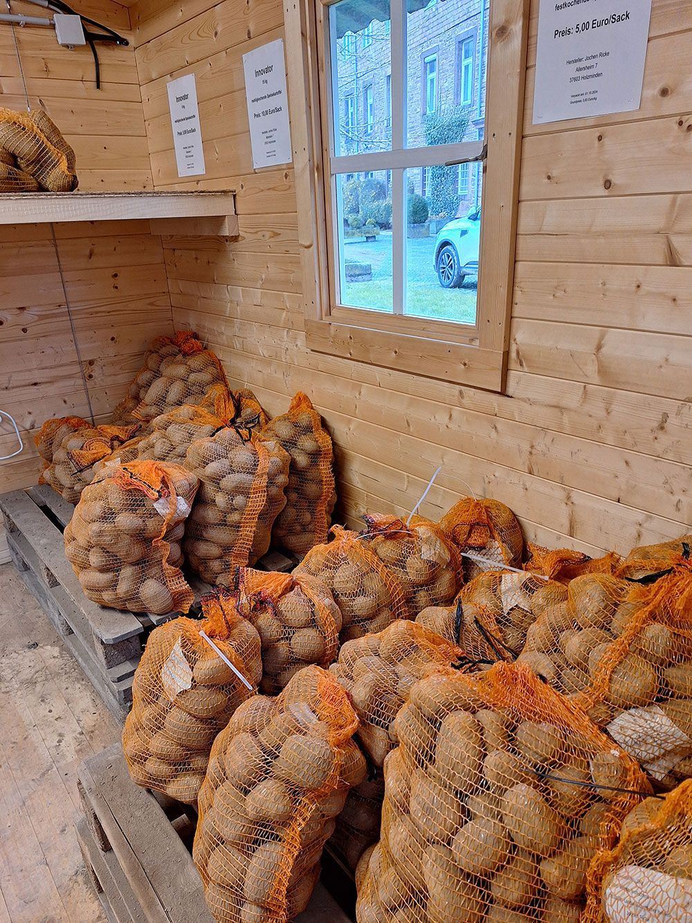 Ein Holzraum voller Kartoffelsäcke.