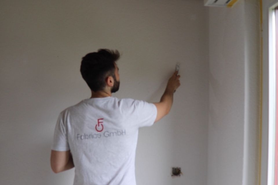 Mitarbeiter der Fabrice GmbH streicht Wand