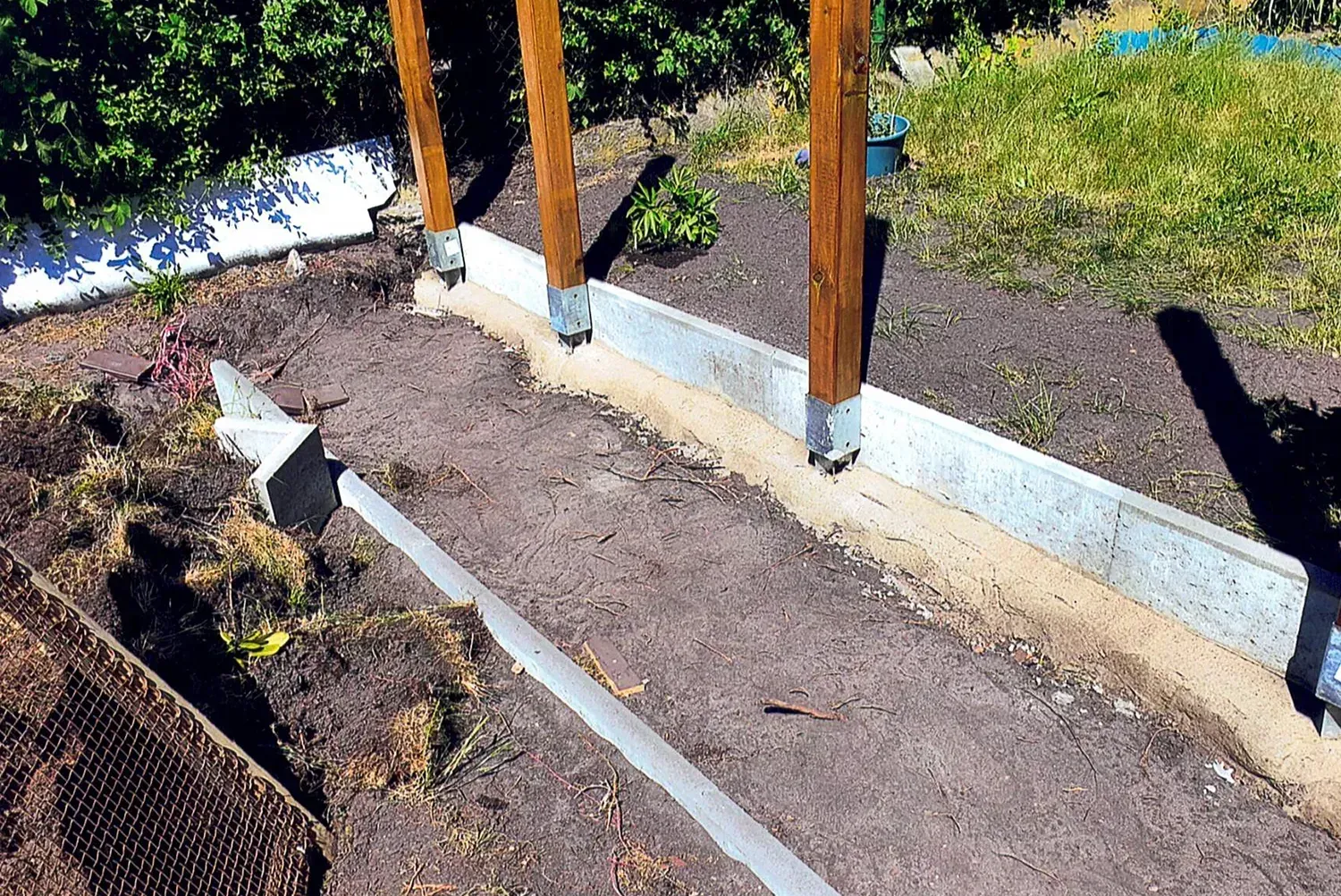 In einem Garten wird ein Holzzaun gebaut.