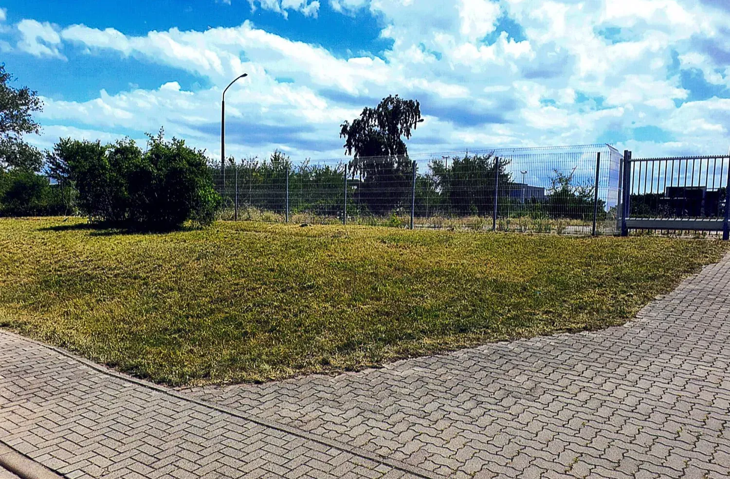 Ein Ziegelweg, der zu einer Wiese führt, mit einem Schild, auf dem steht „Commander“