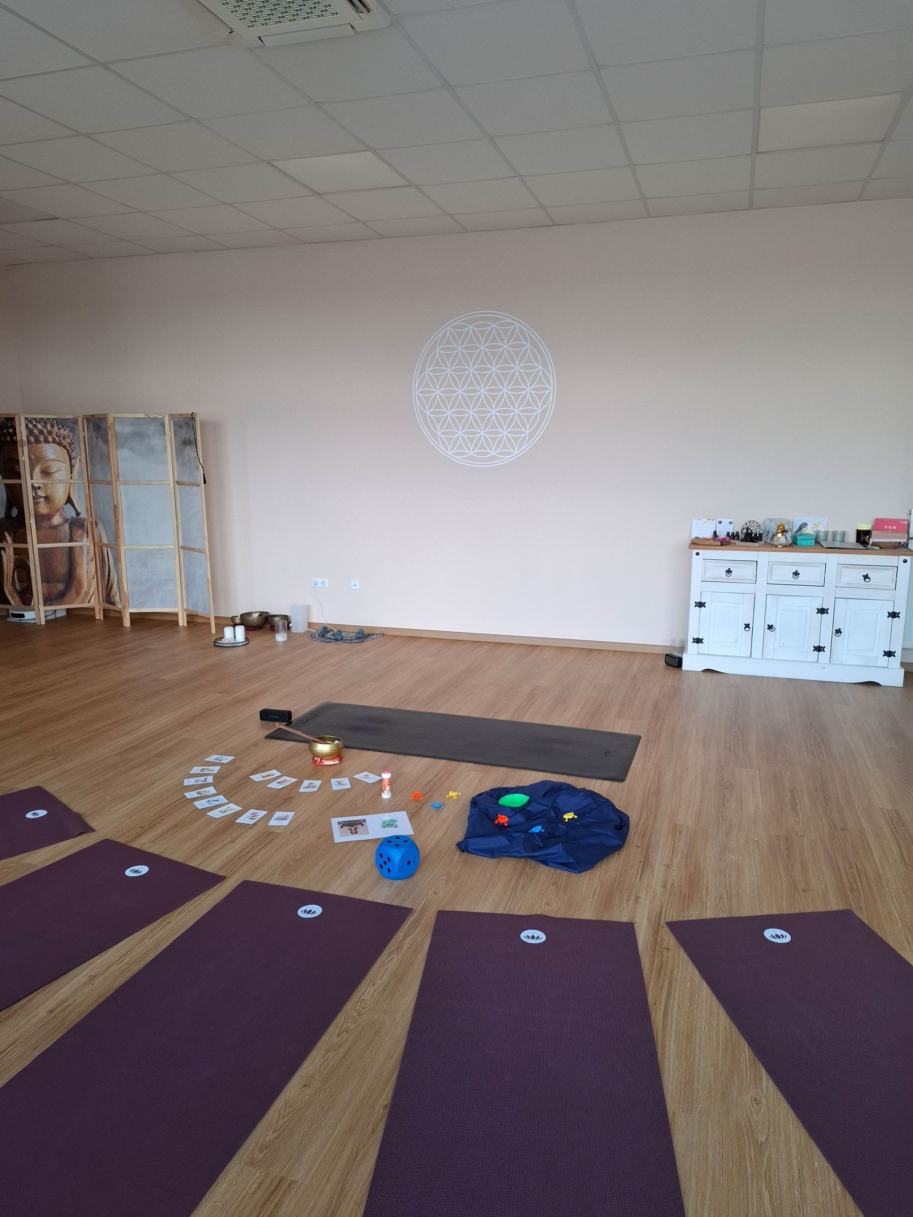 Ein Raum mit lila Yogamatten, die kreisförmig auf dem Boden liegen.