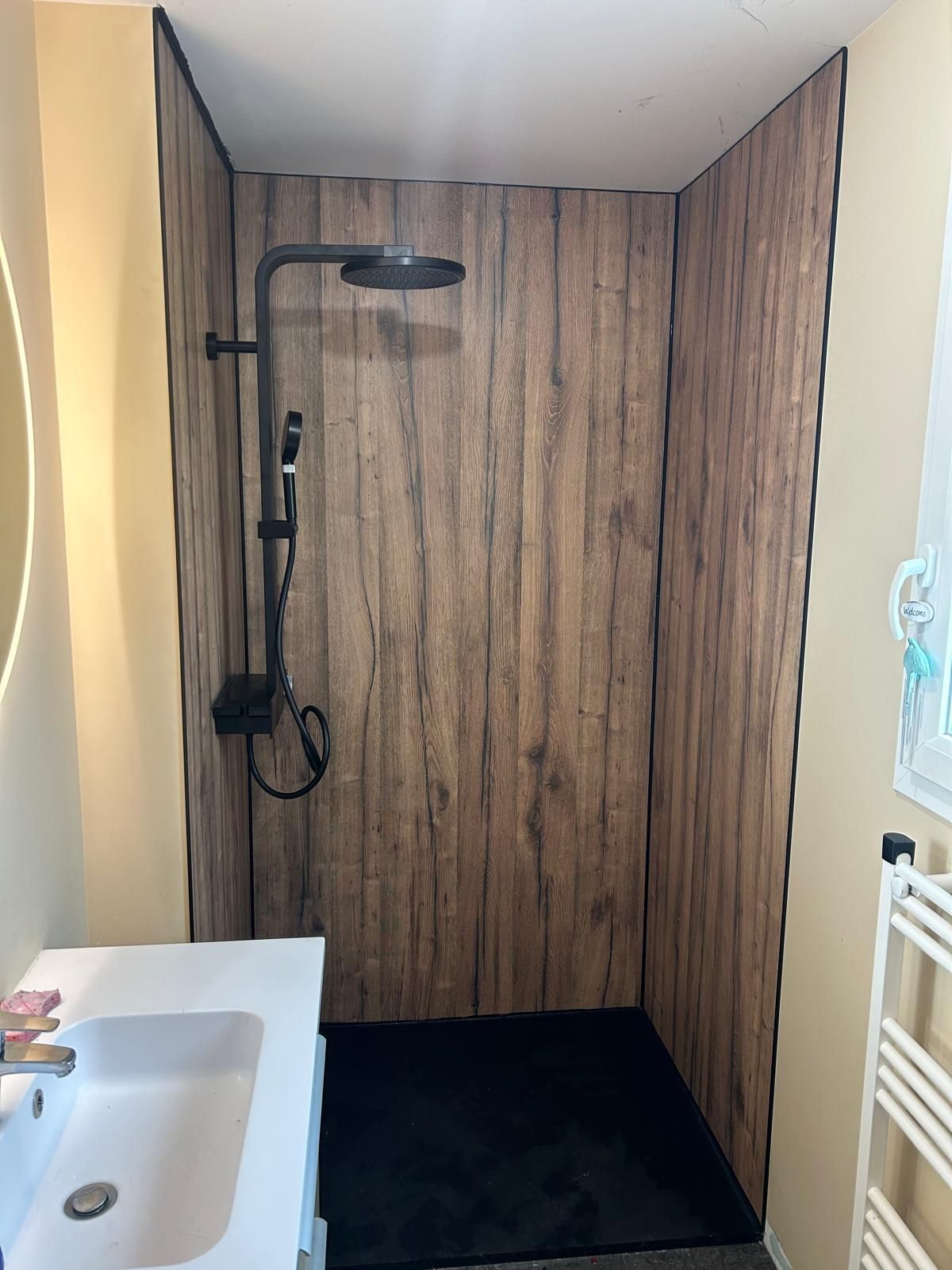 Une douche avec des parois effet bois.