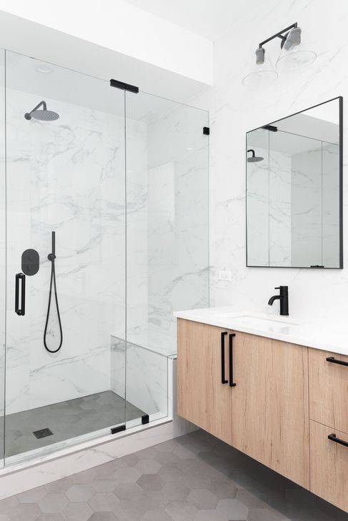 Une salle de bains avec douche, meuble vasque et miroir.