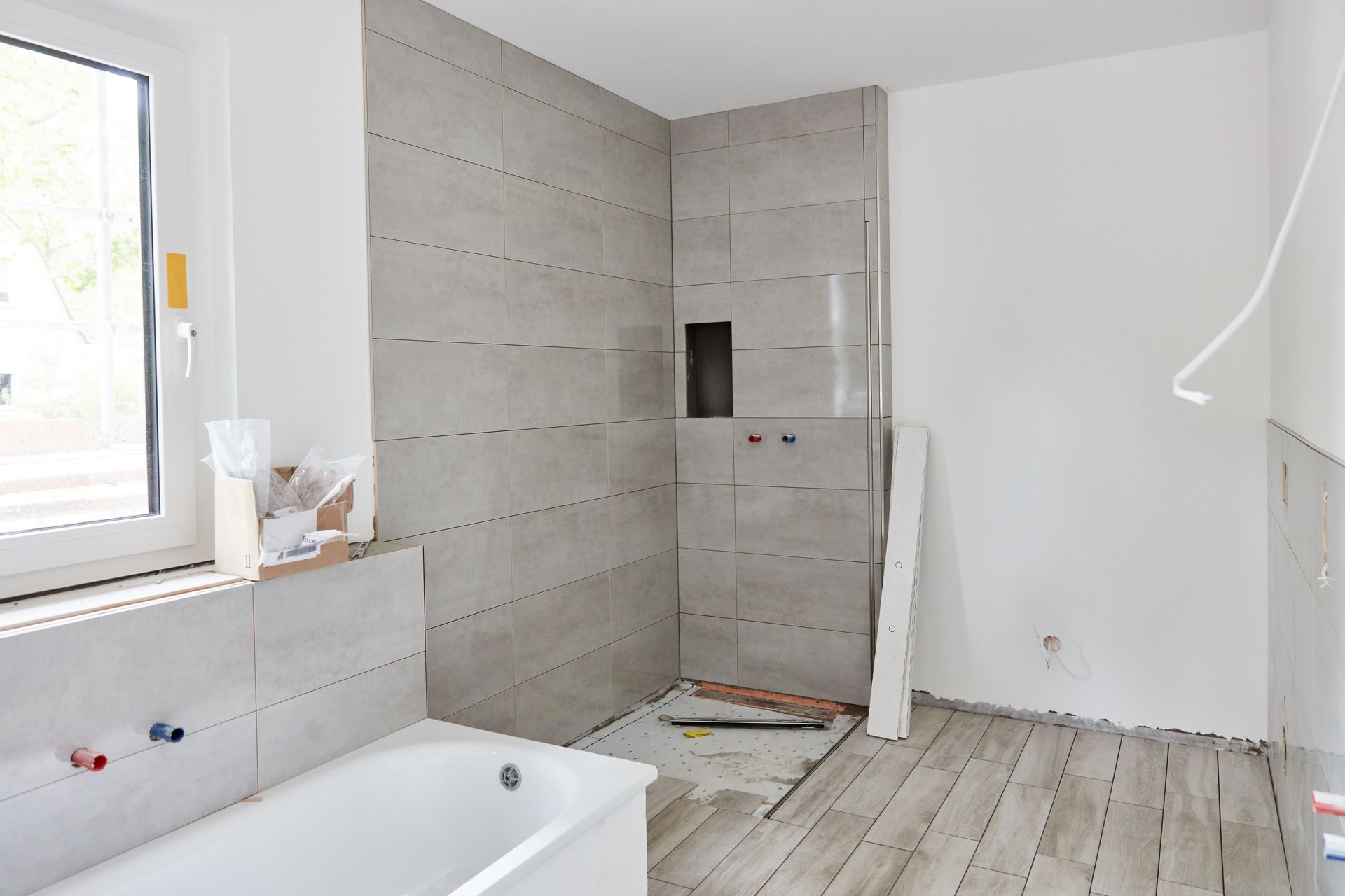 Des travaux en cours dans une salle de bains pour la construction d'une douche.
