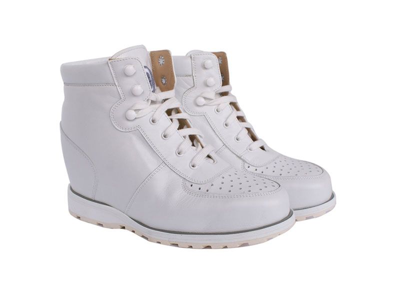 Baskets montantes blanches en cuir perforé avec des détails beiges sur fond blanc