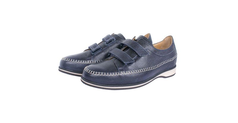 Paire de chaussures en cuir bleu foncé avec des brides Velcro sur fond blanc