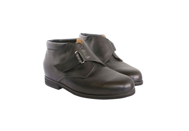 Bottines en cuir noir à boucles sur fond blanc