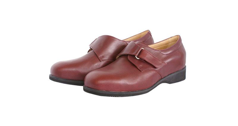 Paire de chaussures habillées en cuir marron avec une bride, sur fond blanc