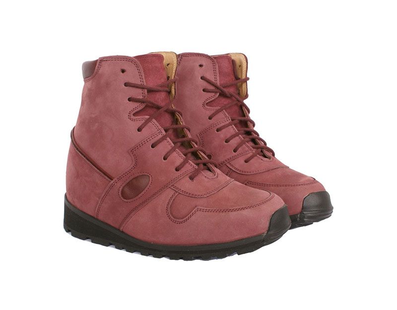 Paire de bottes d'hiver roses à lacets et semelles noires sur fond blanc