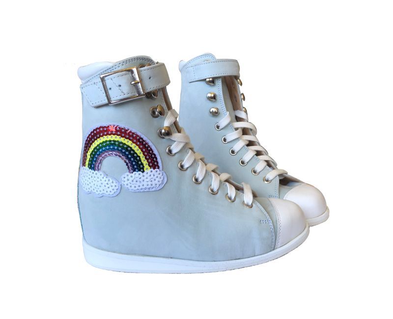 Bottes montantes bleu clair avec des écussons arc-en-ciel et étoiles, des lacets blancs et des boucles.