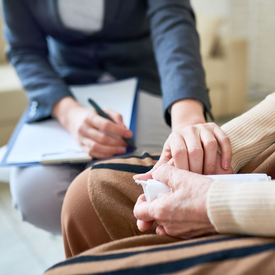Una mujer sostiene la mano de otra mujer mientras está sentada en un sofá.