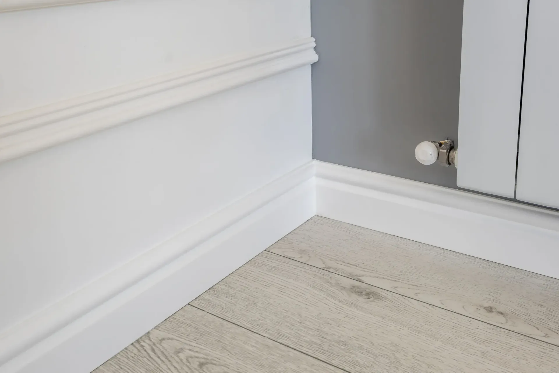 Pasillo con suelo de madera y rodapi&eacute;s instalados a juego