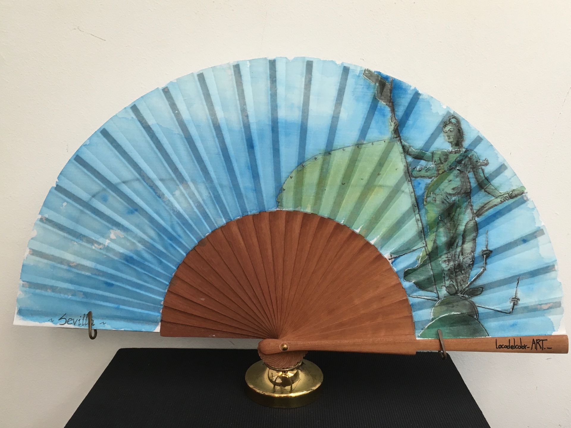 Un abanico con una estatua de la justicia.