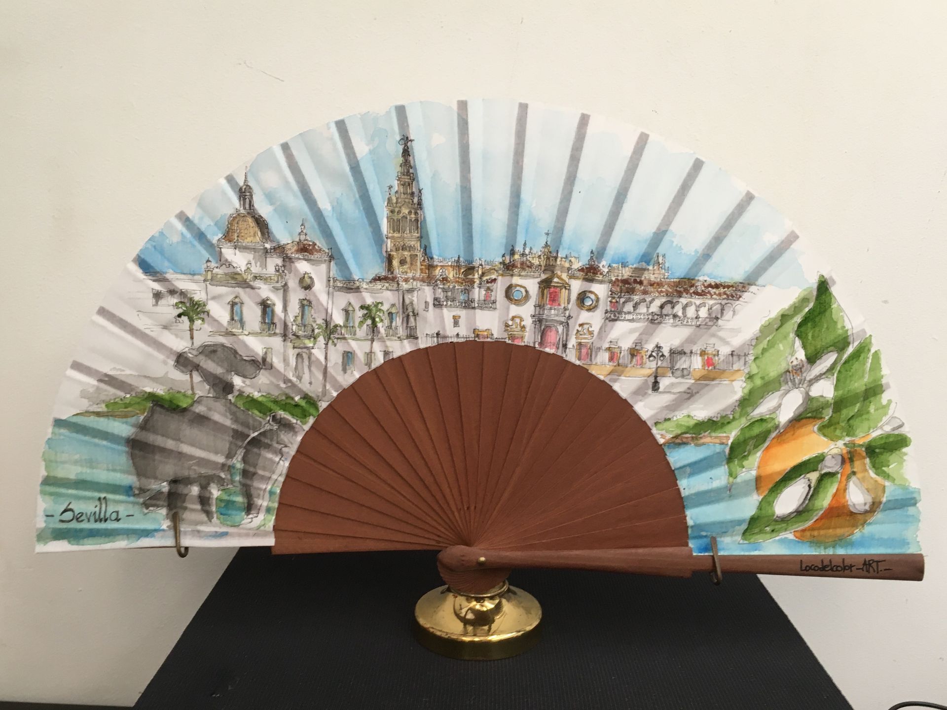 Un abanico con la imagen de un elefante está sobre una mesa.