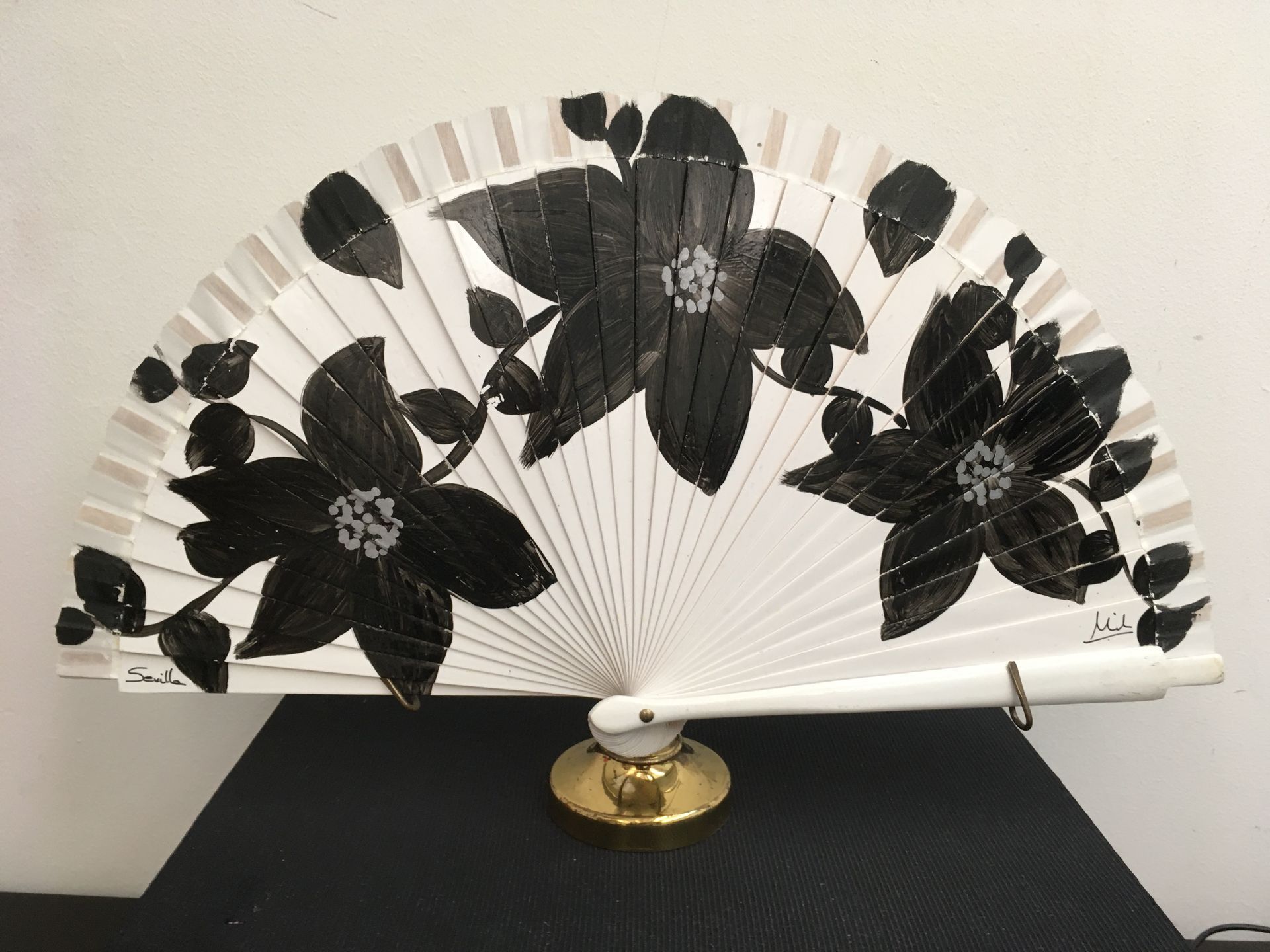 Un abanico blanco con flores negras.