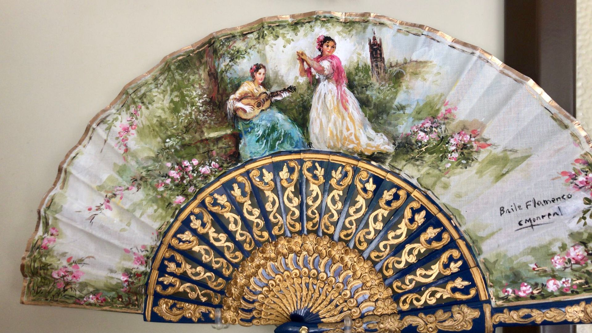 Un abanico con una pintura de dos mujeres.