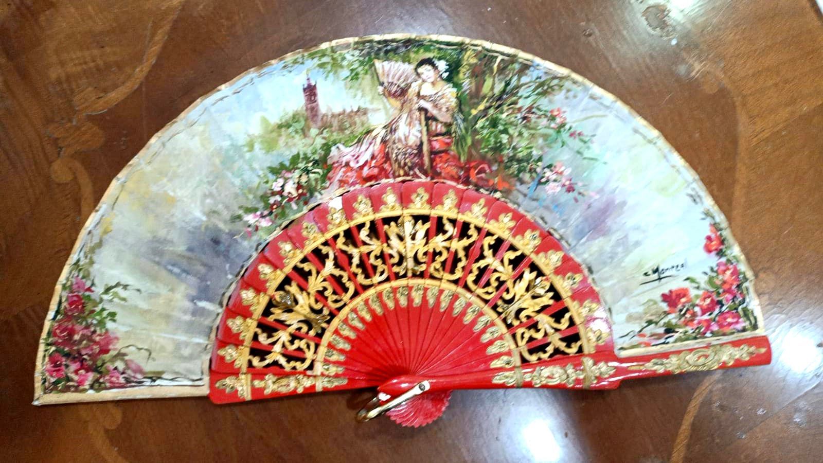 Un abanico rojo con la imagen de una mujer.