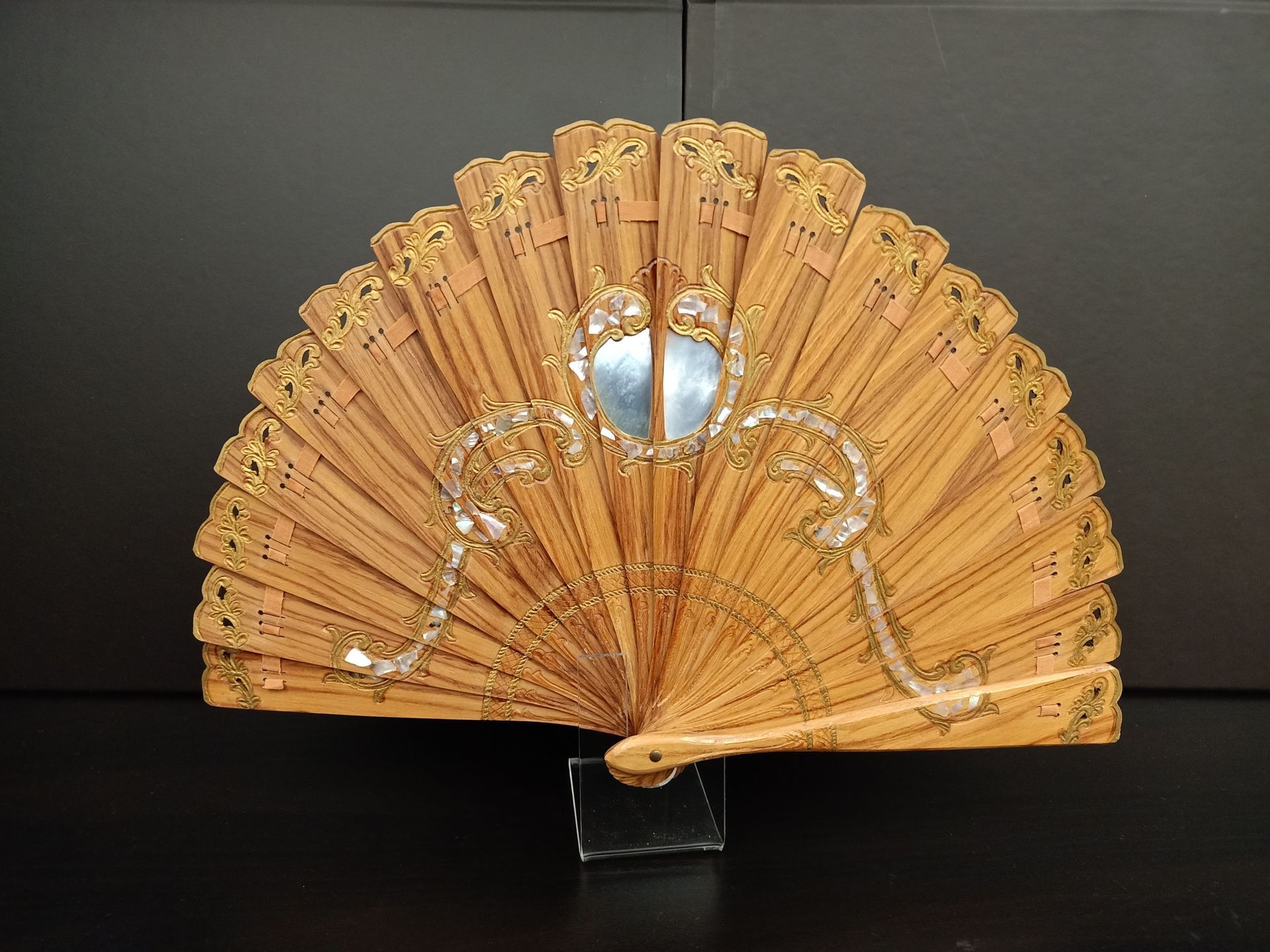 Un abanico de madera con un espejo en el medio.