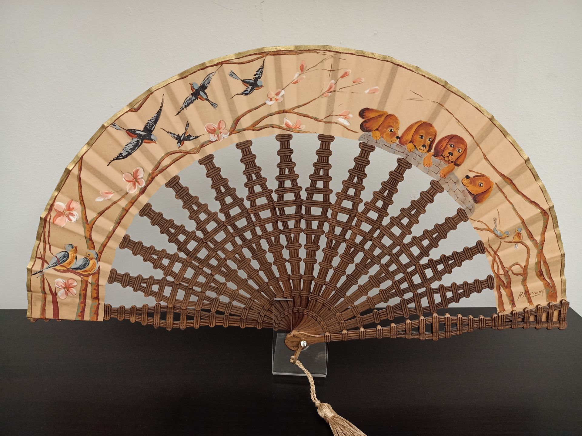 Un abanico con pájaros y flores.