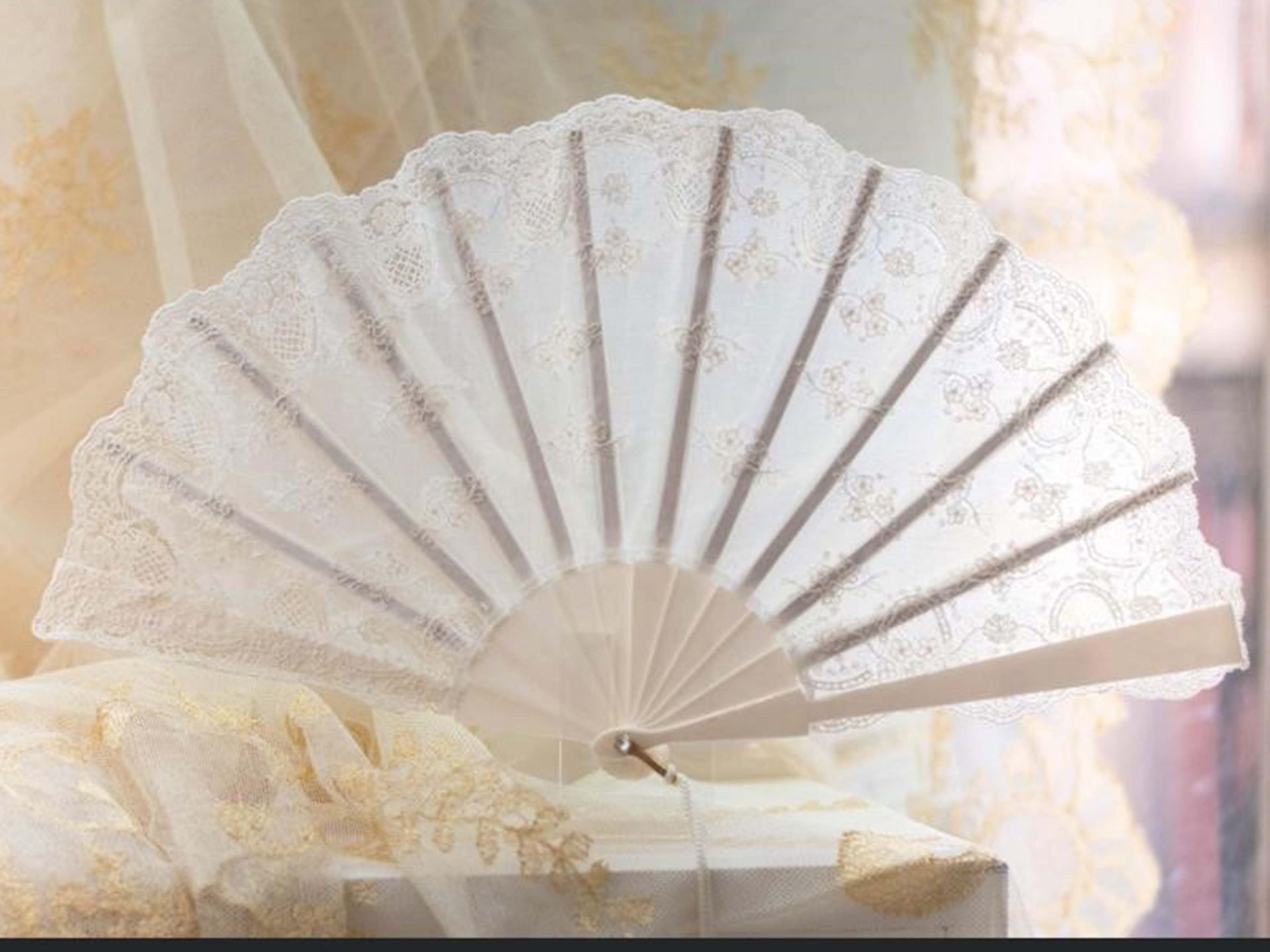 Un ventilador blanco está sentado encima de una caja blanca.