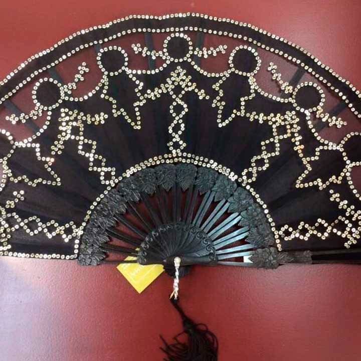 Un abanico negro con diamantes de imitación dorados.