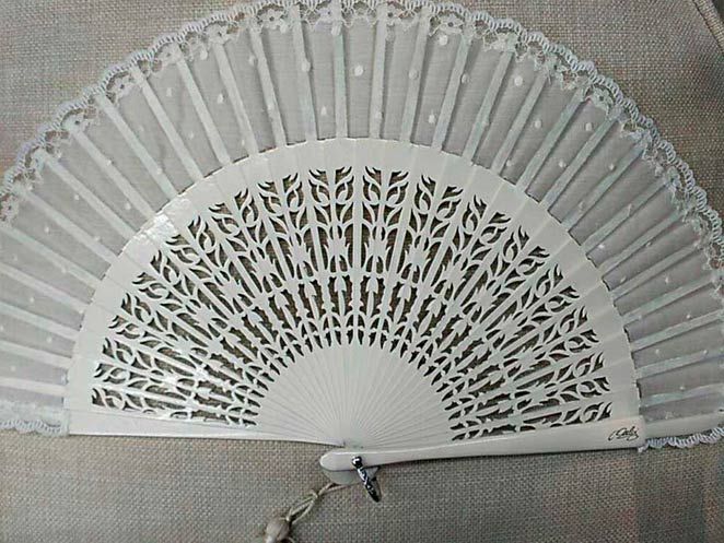 Un abanico blanco con lunares está sentado en un sofá.