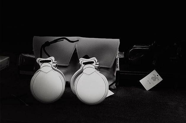 Un par de castañuelas blancas están sobre una mesa en una fotografía en blanco y negro.