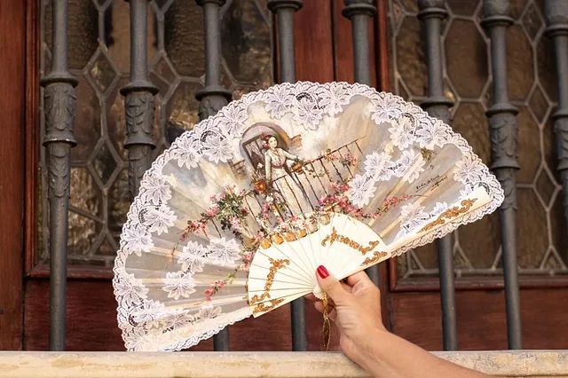 Una mujer sostiene un abanico con una imagen de Jesús.