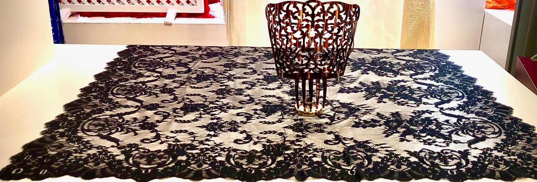 Un camino de mesa de encaje negro con un peine encima.
